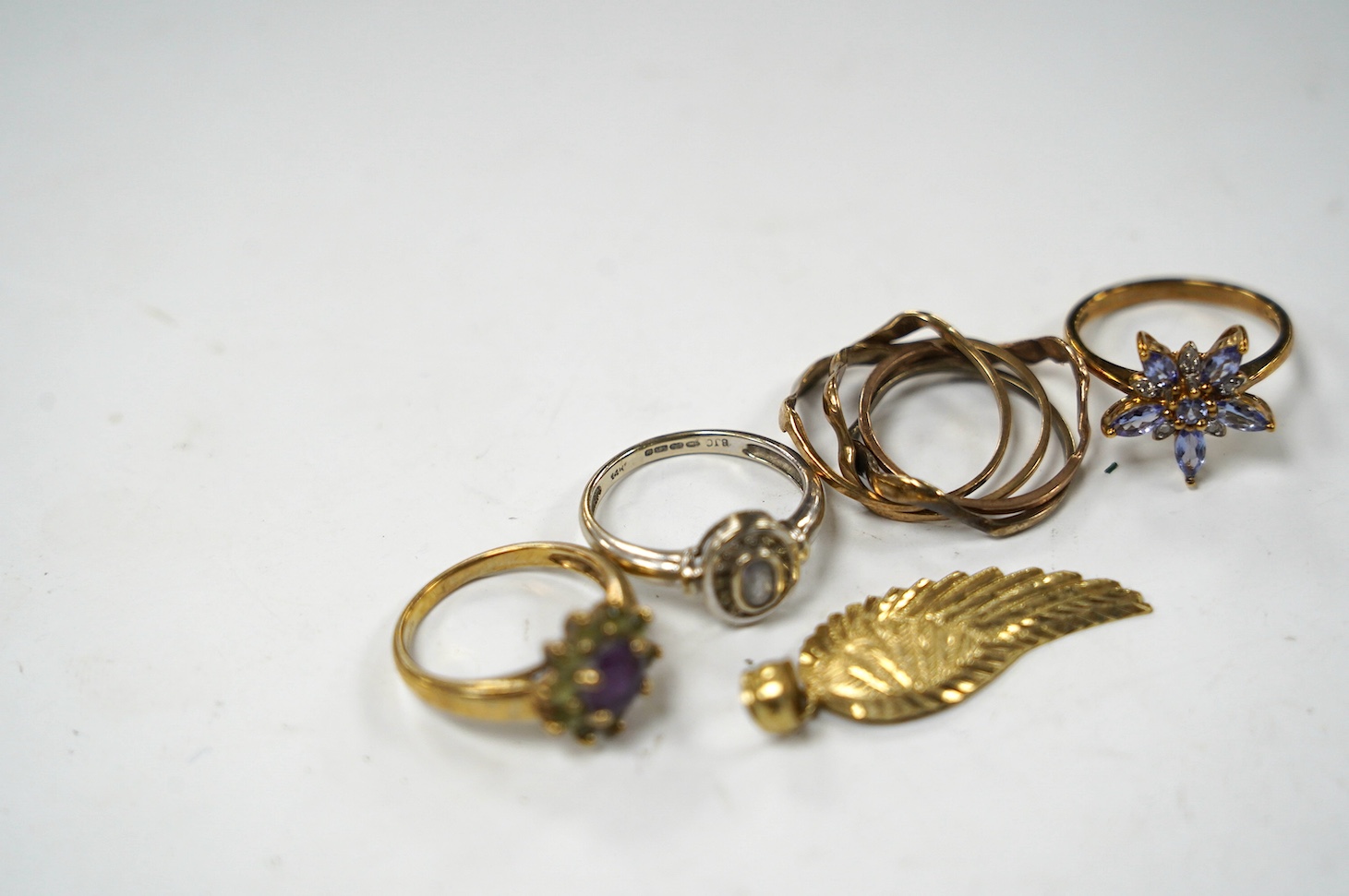 A modern 14k and gem set cluster ring, size L, gross weight 2.5 grams, together with three assorted 9ct rings, including gem set and a 9k leaf pendant, gross weight 10.8 grams. Condition - poor to fair